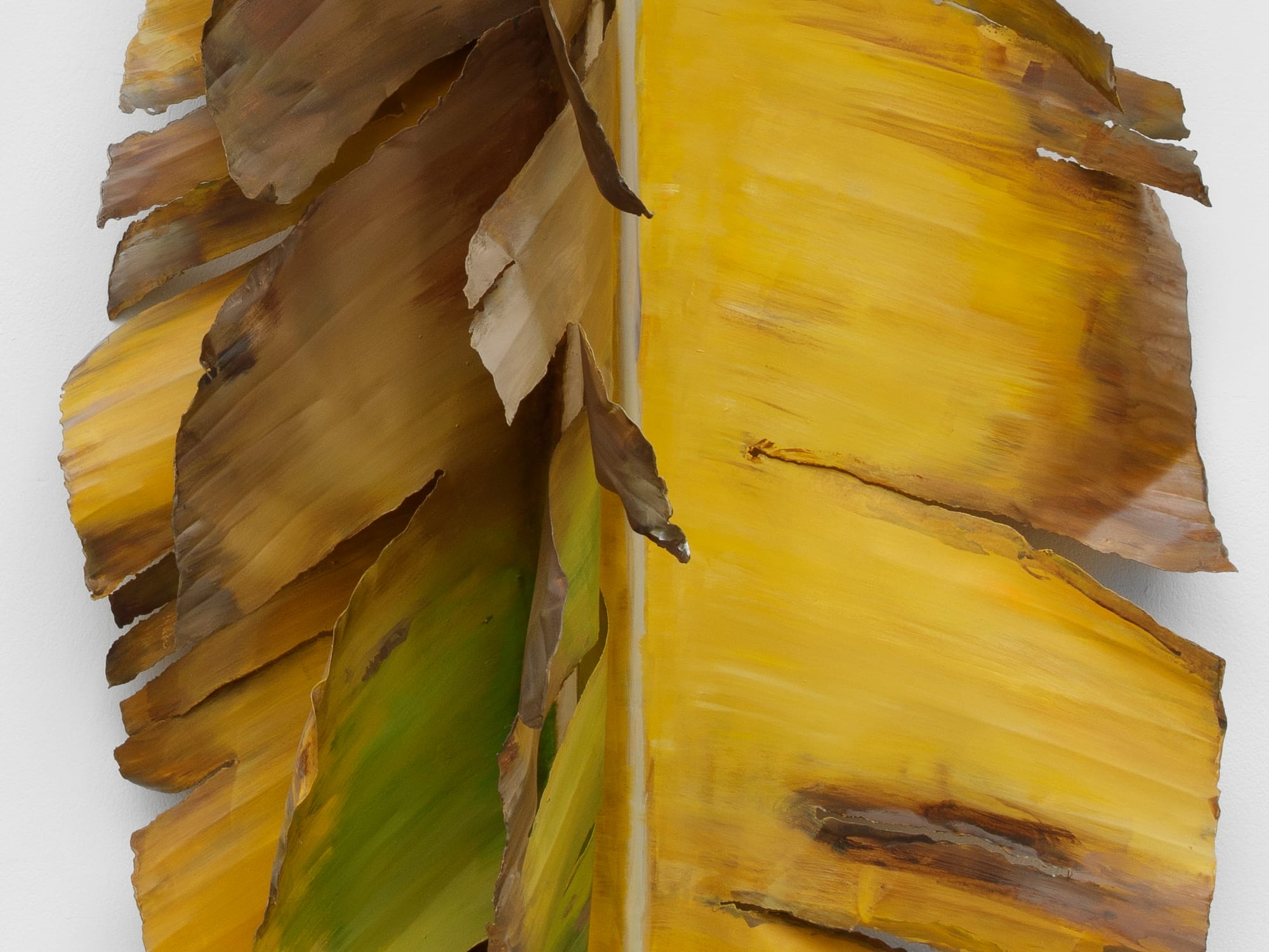 a detail image of a metal leaf by Alvaro Urbano that appears to be dying and turning brown and yellow