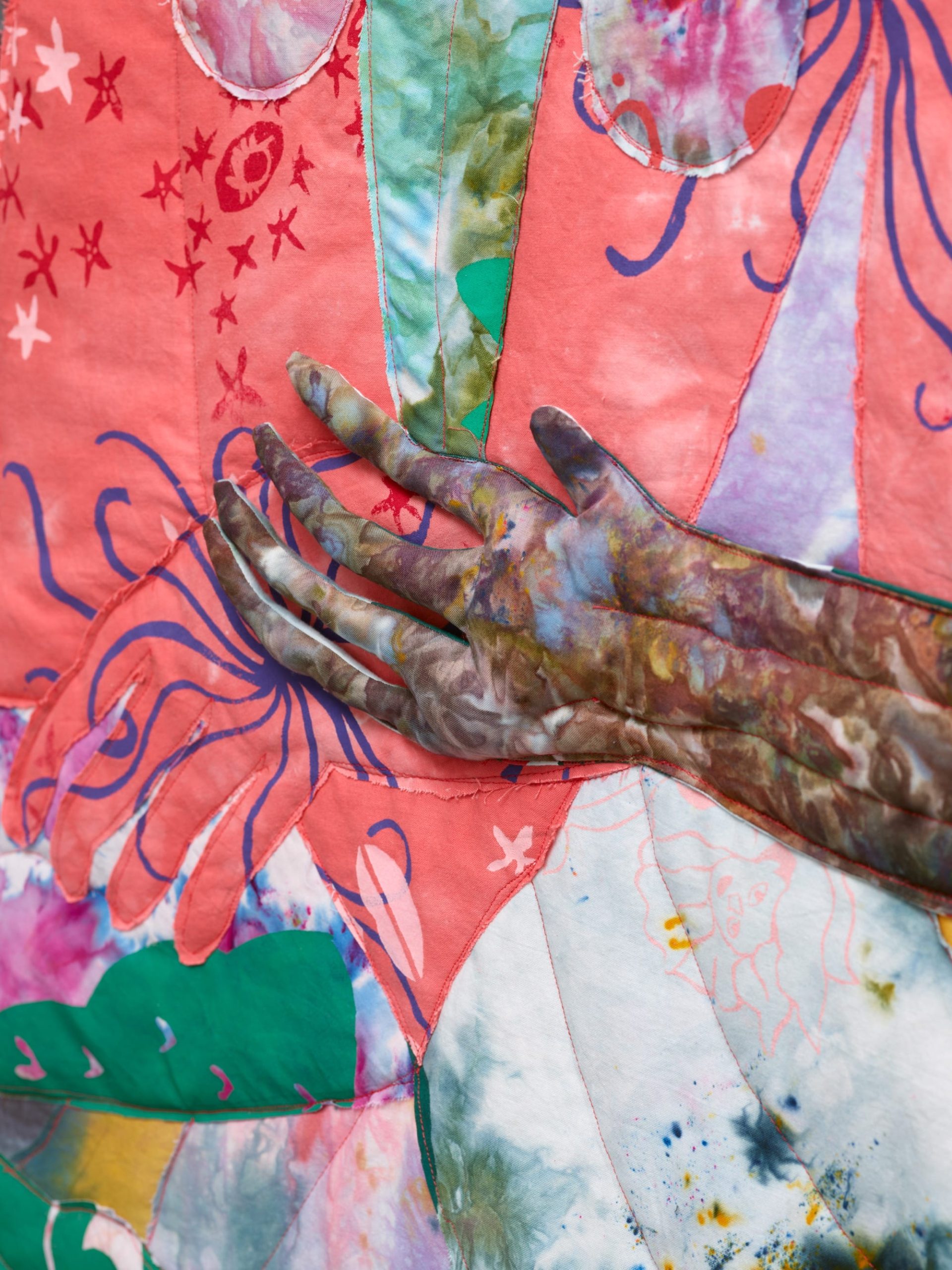 detail of a textile hand on vivid, patterned fabric