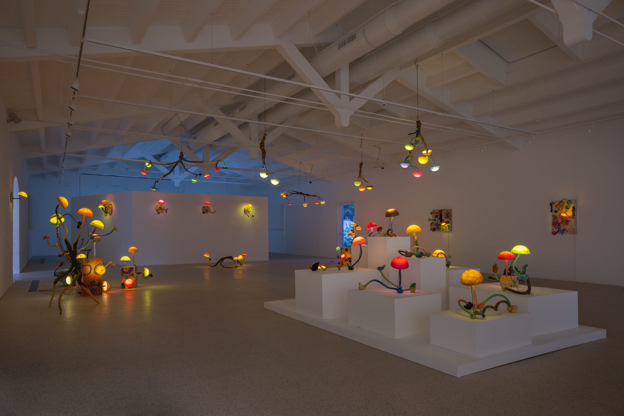 an installation of illuminated mushroom sculptures by Mika Rottenberg in a large white gallery space