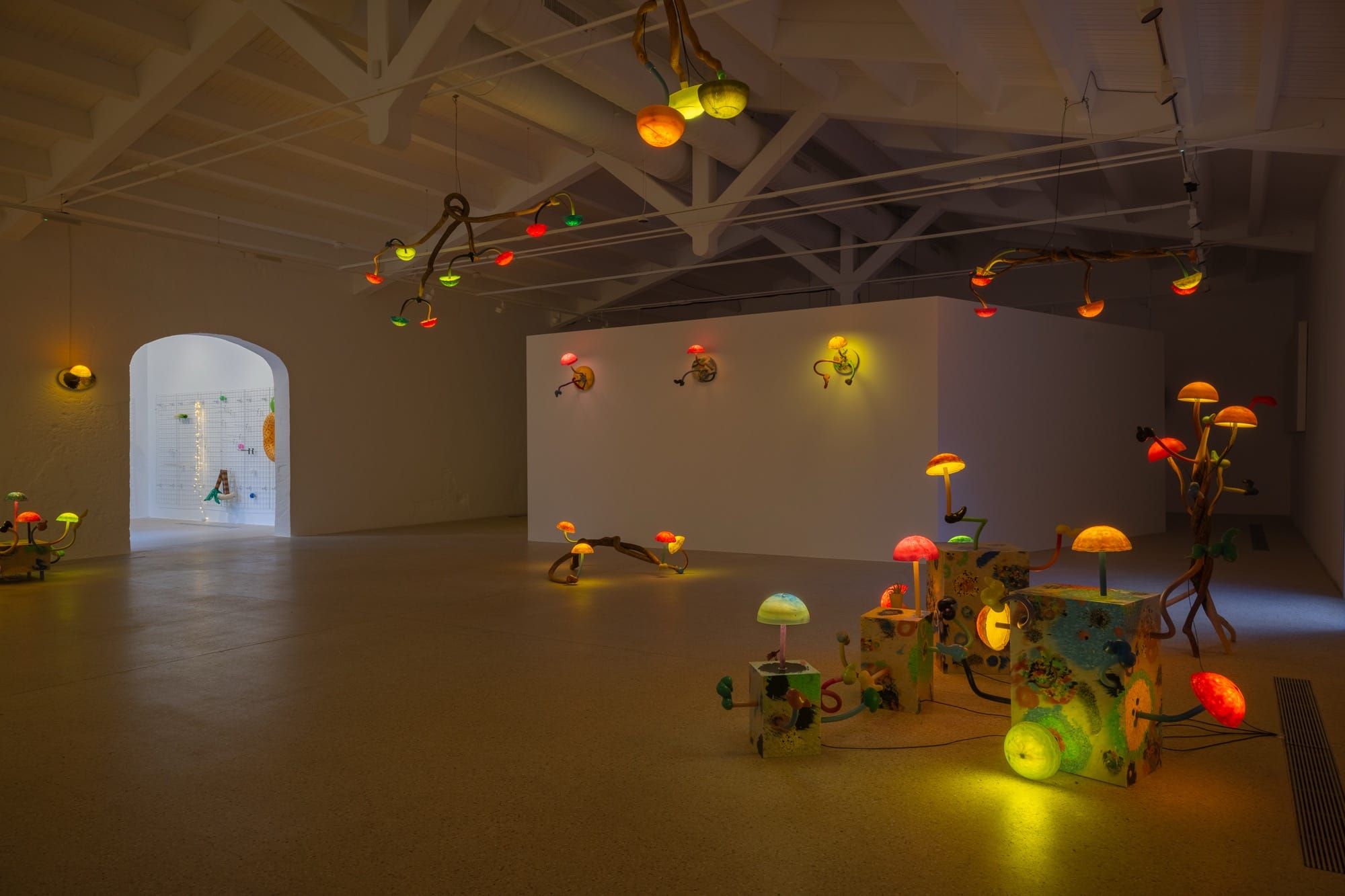 an installation of illuminated mushroom sculptures by Mika Rottenberg in a large white gallery space